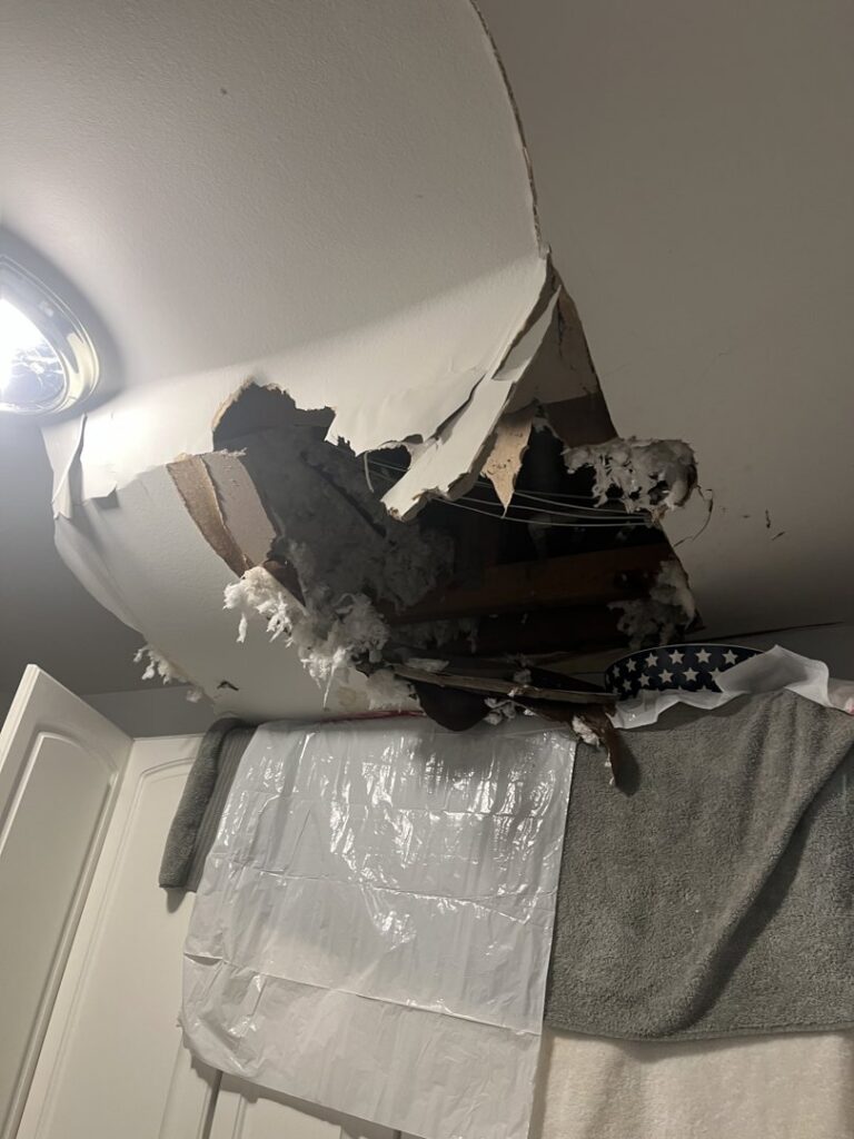 Ceiling damage with exposed insulation, likely from a water leak, requiring repair by Komfort Air Service Experts in Charlotte, NC.