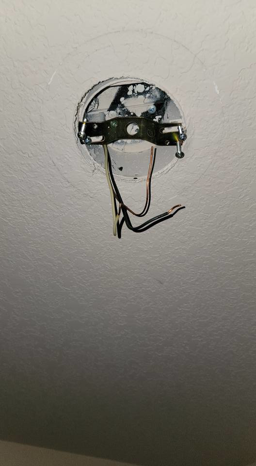 Exposed electrical wiring and mounting bracket for a ceiling light fixture installation by Rain Man Thee Handyman in Hampton, VA.