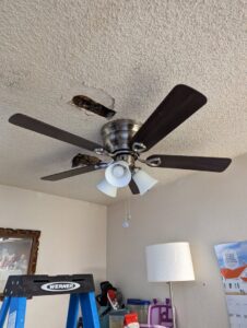 A ceiling fan with exposed wiring, indicating an ongoing installation or repair project by Primo's Electrical Services in San Diego, CA.