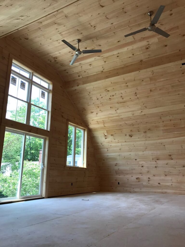 Two ceiling fans installed in a room with wooden walls and ceiling by T.S.F Electric in Saco, ME.