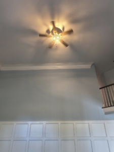 A newly installed ceiling fan with a light fixture illuminating a room by Eastern Electrical Contractors in Waterbury, CT.
