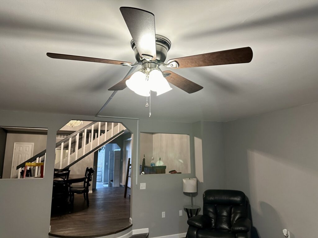 A newly installed ceiling fan with integrated lighting in a living room by Lighten Up Electric, LLC in Cranston, RI.
