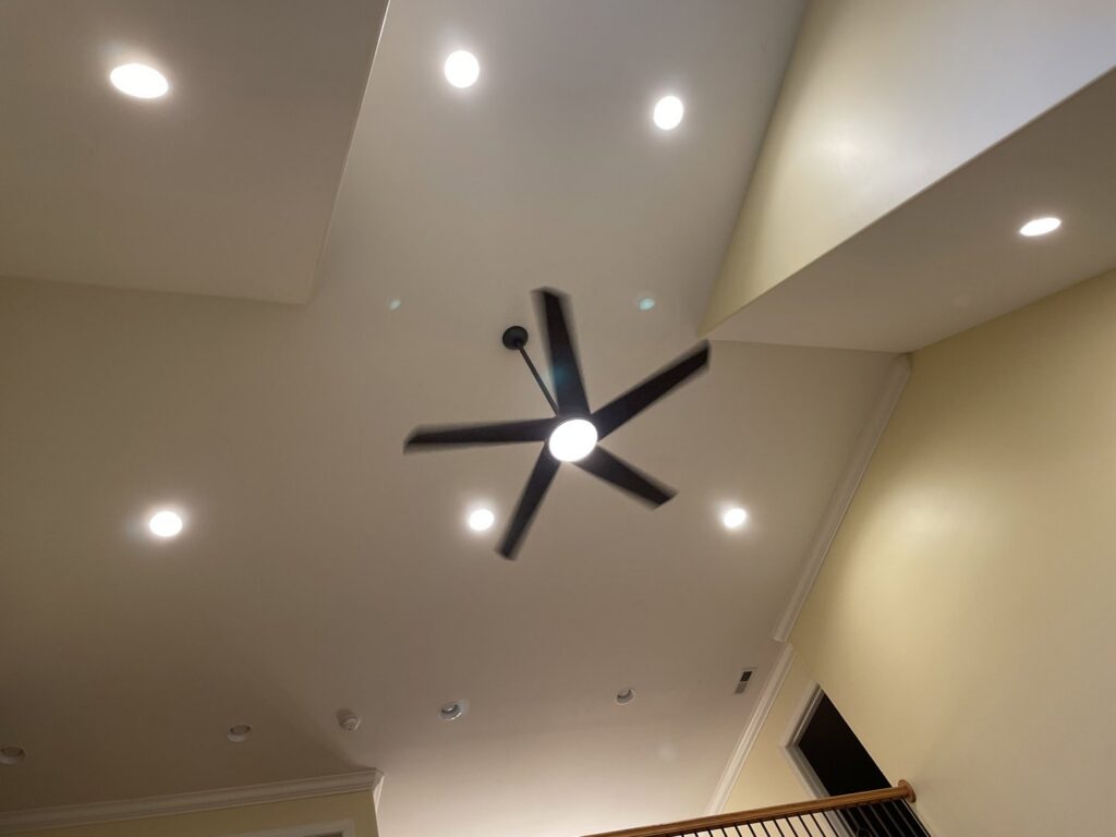 Installed ceiling fan and recessed lights in a modern ceiling by HLR Electric Company, LLC in Durham, NC.