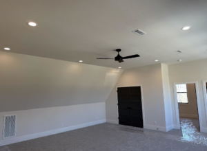 A newly installed ceiling fan and recessed lighting fixtures in a room by HMH Electric, your electrician in Fayetteville, AR.