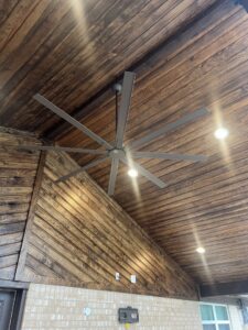 A large ceiling fan and recessed lighting installed on a wooden ceiling by Llanos Electric Builders in Houston, TX.