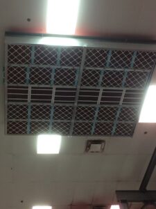 Ceiling view showing multiple HVAC air filters and return grilles installed by Montefusco HVAC in Peoria, IL