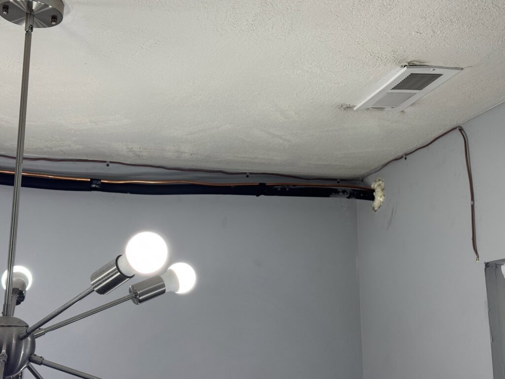 A ceiling HVAC vent and refrigerant lines installed by Inspired Heating & Cooling, Electric, Roofing, Repair LLC in Columbus, OH.