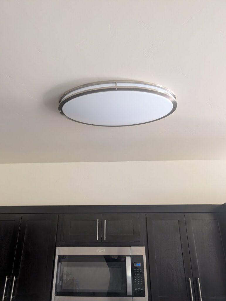 A modern ceiling light fixture installed above kitchen cabinets by LE Electric in Las Cruces, NM