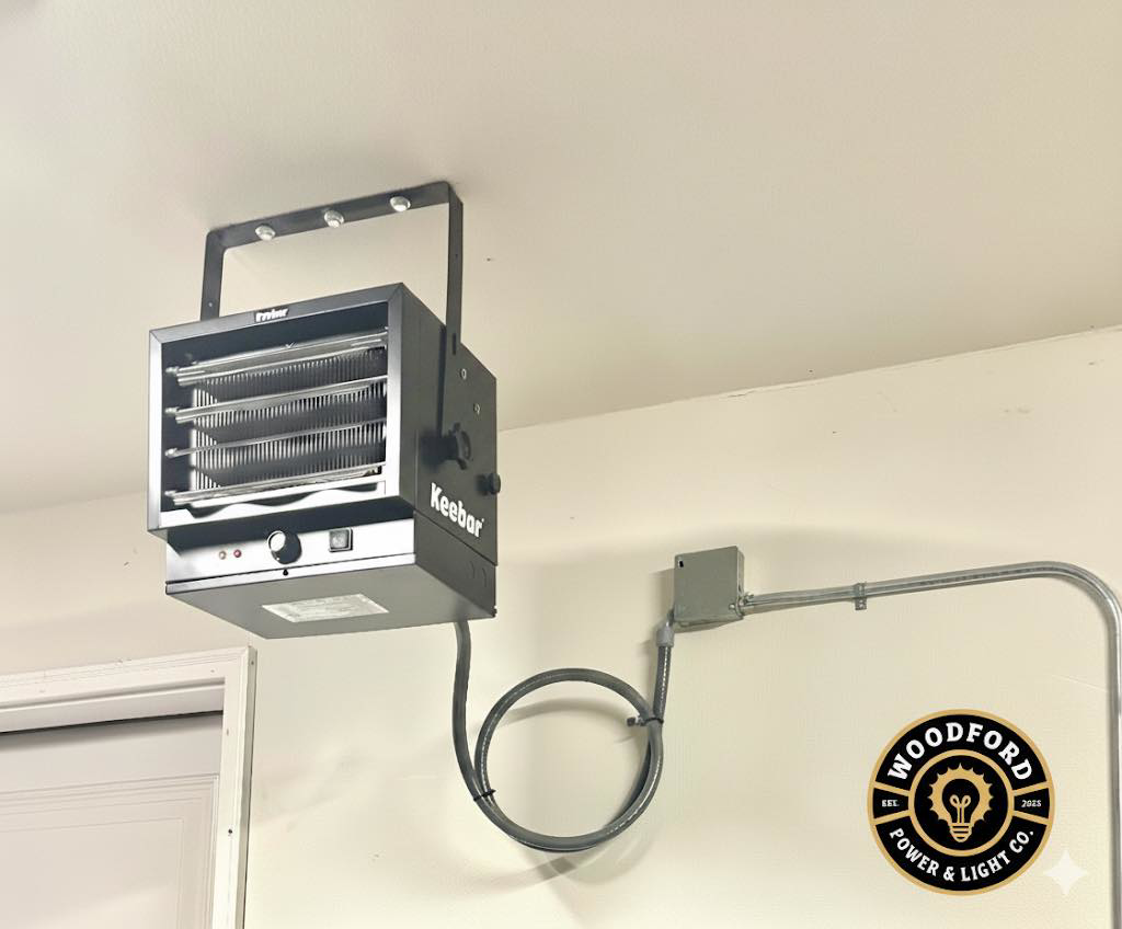 A ceiling-mounted electric heater with professional conduit wiring installed by Woodford Power & Light Co. in Ankeny, IA.