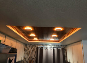 Custom ceiling with recessed lighting and a decorative wood panel installed by Intel-electric in Anchorage, AK