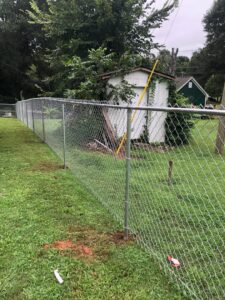 A newly installed chain-link fence enclosing a residential backyard by Fenceitforu LLC in Matthews, NC.