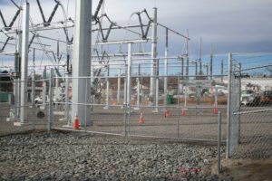 A chain-link fence with barbed wire protecting an electrical substation, installed by Life Time Fence, Inc. in Cedar Rapids, IA.