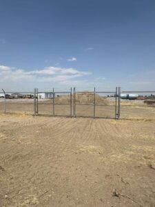 Chain link double gate with barbed wire top installed by Cowboy State Fencing LLC in Riverton, WY.