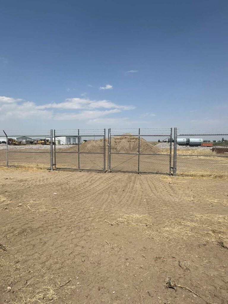 Chain link double gate with barbed wire top installed by Cowboy State Fencing LLC in Riverton, WY.