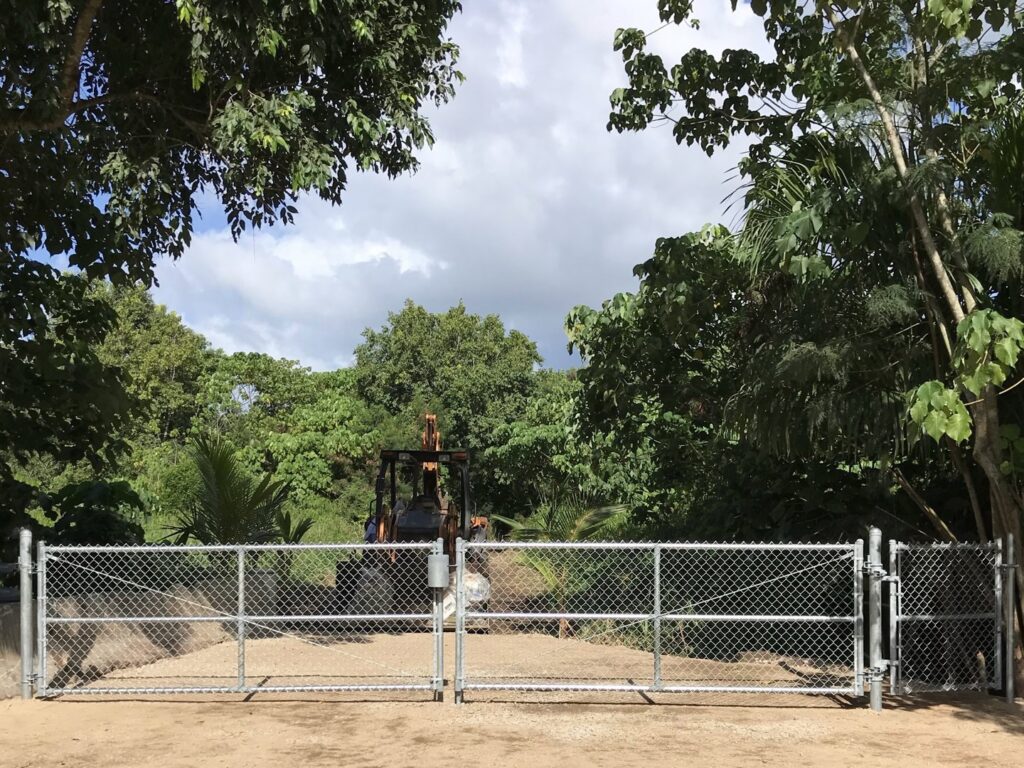 A large chain-link double gate installation in a rural setting by 702 Fence LLC in Las Vegas, NV.