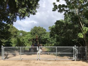 A large chain-link double gate installation in a rural setting by 702 Fence LLC in Las Vegas, NV.
