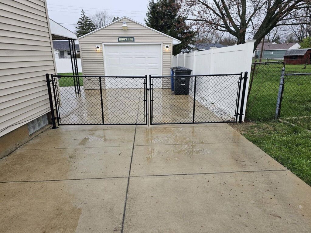 Two black chain link gates installed for a driveway by Barney's Landscaping in Dayton, OH.