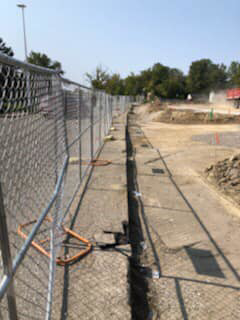 Chain-link fence installed along an active construction trench by HP Fence in Warren, MI.