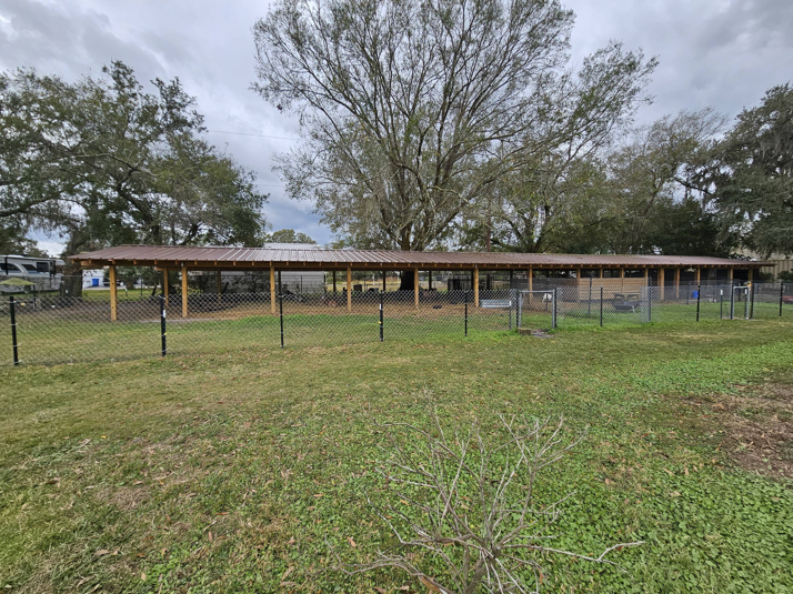 A long chain-link fence enclosing a covered animal pen built by The Johnson Family Fencing in Tampa, FL.