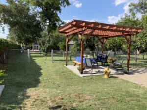 A chain-link fence installed around a backyard featuring a wooden pergola by Competitive Fence Contractors LLC in Scottsdale, AZ.