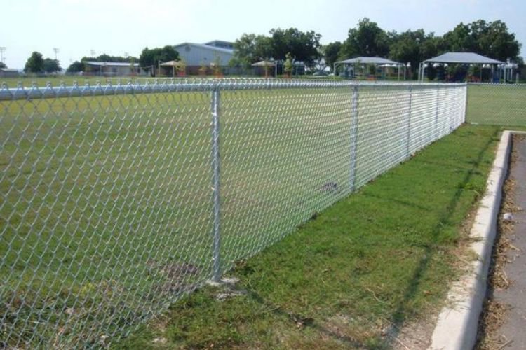 A chain link fence installed around a grassy field by Fence Company of Rhode Island in Providence, RI.