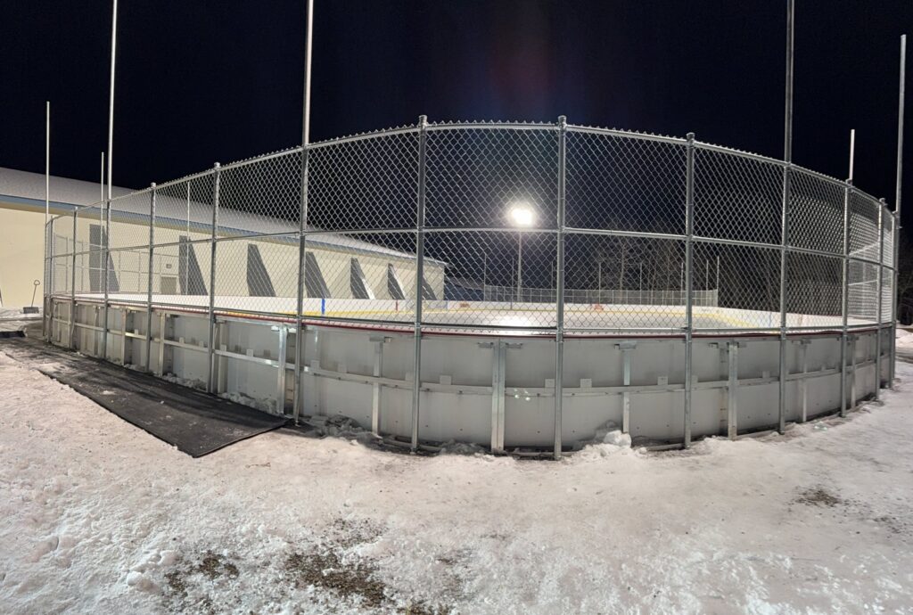 A sturdy chain-link fence surrounding an outdoor ice rink, installed by Thrive Fencing in Ames, IA.