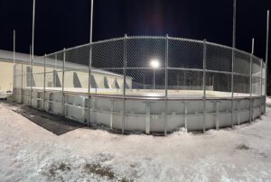 A sturdy chain-link fence surrounding an outdoor ice rink, installed by Thrive Fencing in Ames, IA.