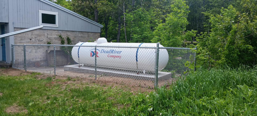 A newly installed chain-link fence enclosing a large propane tank next to a building by Profence in Leander, TX.