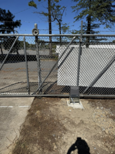 A robust chain-link fence with barbed wire and an automatic gate opener installed by Littleton Construction LLC in the Service Area.