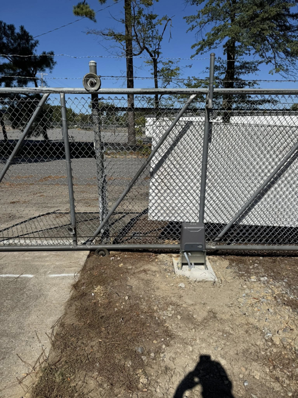 A robust chain-link fence with barbed wire and an automatic gate opener installed by Littleton Construction LLC in the Service Area.