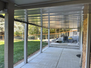 A backyard patio area with a chain-link fence visible in the background, installed by North CO Fence & Deck in Greeley, CO.