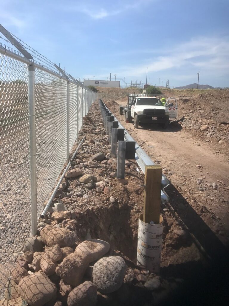 Chain-link fence with barbed wire being installed along a property line by SFA Contracting LLC in Tucson, AZ.