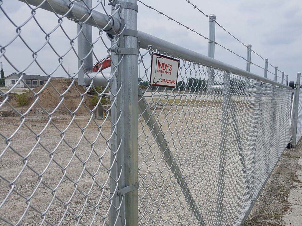 A commercial chain-link fence with barbed wire on top, installed by Morton Fence Solutions LLC in Indianapolis, IN.