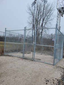 A secure chain-link fence with barbed wire enclosing utility equipment, installed by ALL STAR FENCE in Chicago, IL.