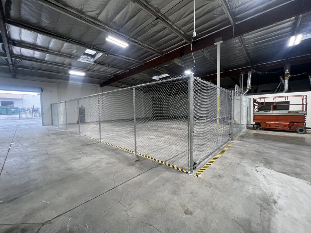 A chain link fence enclosure installed inside a warehouse by No Limit Fence Company in Huntington Beach, CA.