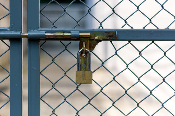 A close-up of a chain-link fence gate secured with a padlock, installed by Palmetto Fence Co in North Charleston, SC.