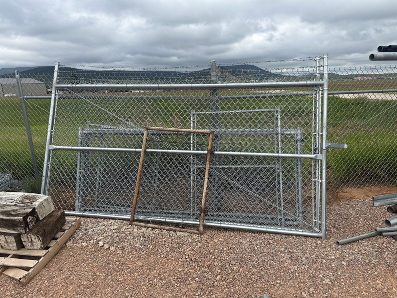 Chain link fence gates with barbed wire, ready for installation by Fence Tech Services, LLC in Sundance, WY.