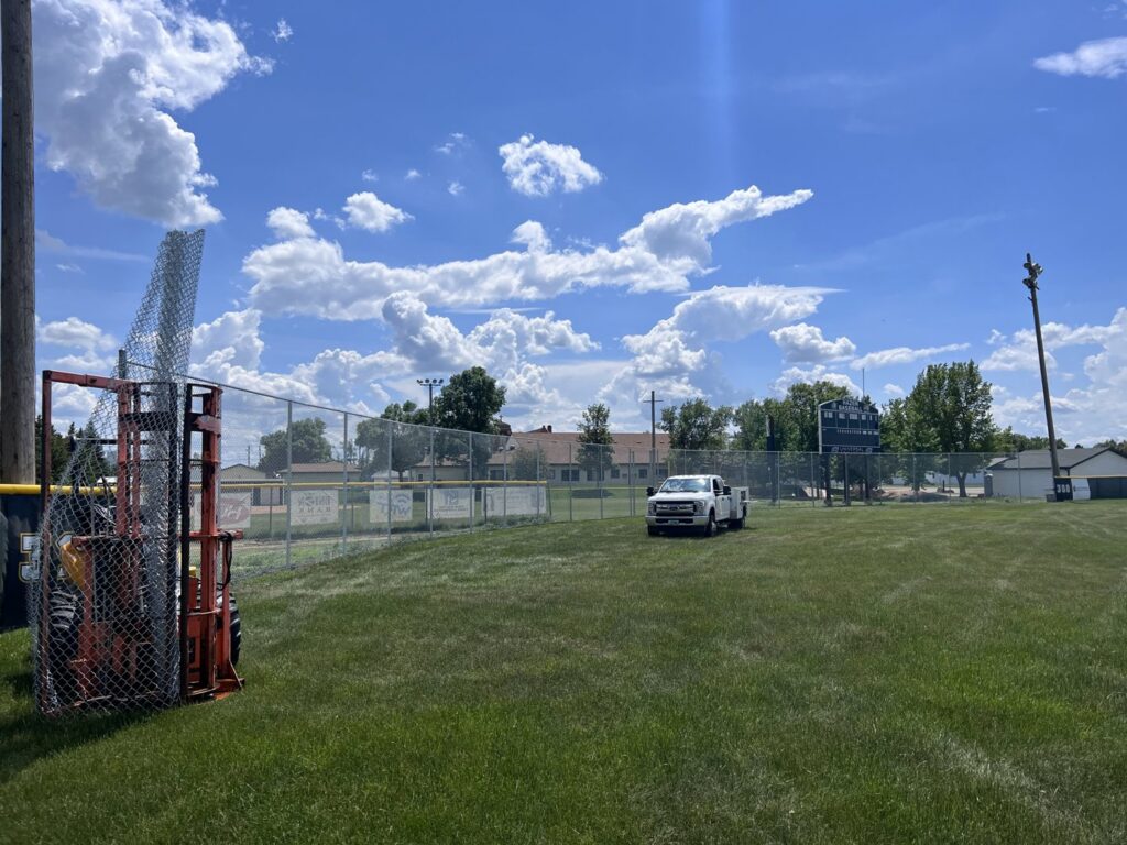 Chain-link fence installation in progress at a baseball field by Western Fence in Hebron, ND.