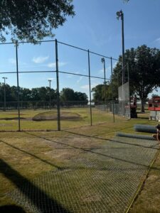 Chain-link fence being installed around a sports field by Smithfield Fence in Crowder, MS.