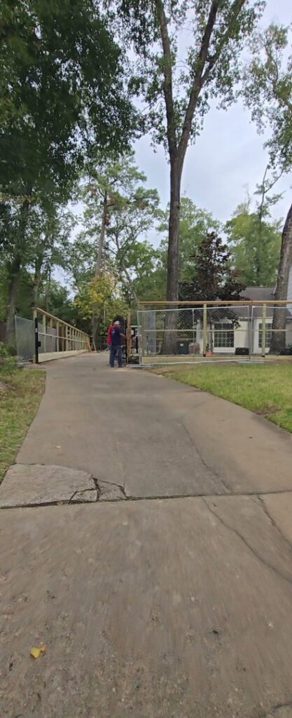 A worker installing a chain link fence, demonstrating the professional services of Fence Builders of Houston, TX.