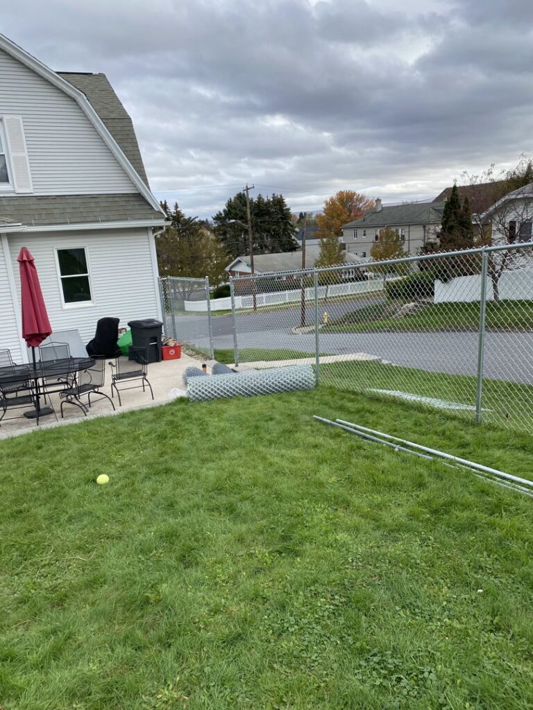 Chain-link fence materials and posts on the ground, indicating an installation by The Fence Dr. in Scranton, PA.