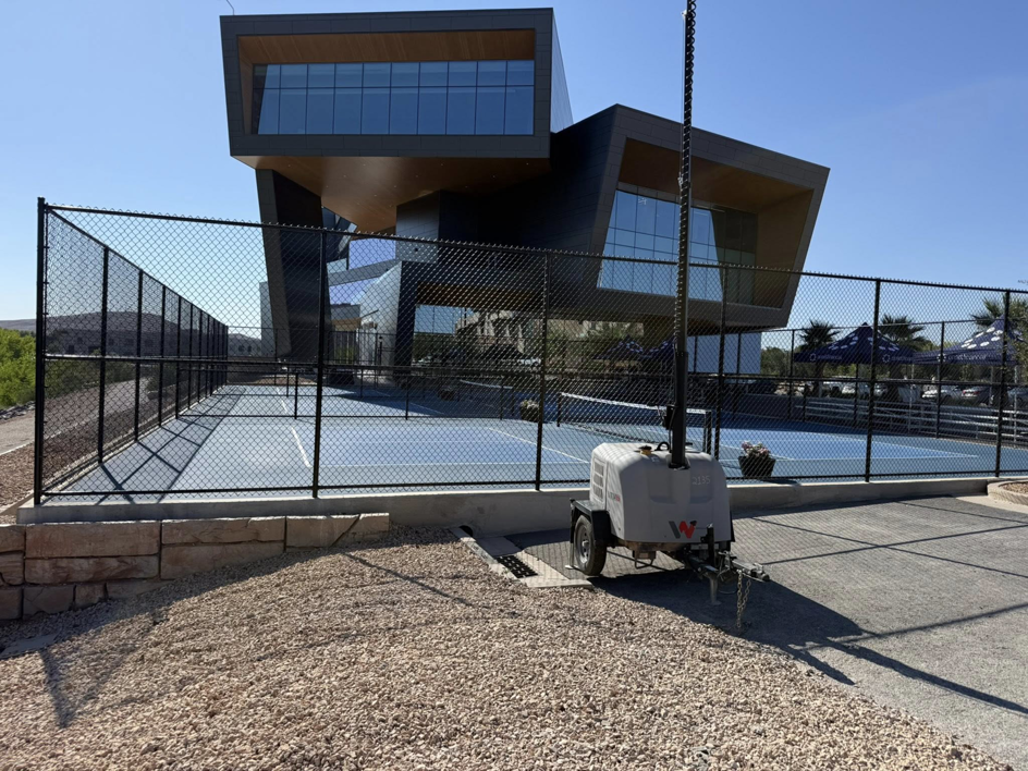 A newly installed black chain-link fence surrounding a pickleball court by Legacy Fencing LLC in St. George, UT.