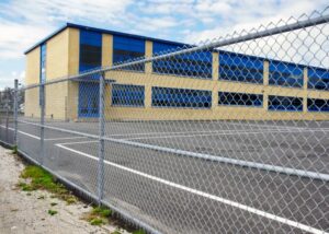 A chain link fence installed around a school building and playground by Fence Company of Rhode Island in Providence, RI.