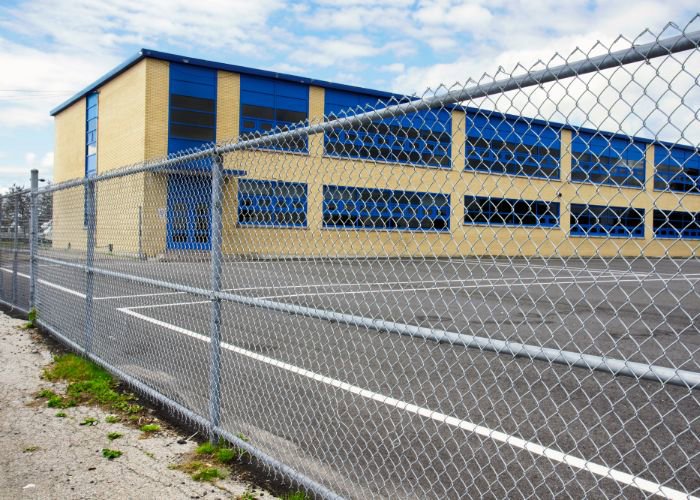 A chain link fence installed around a school building and playground by Fence Company of Rhode Island in Providence, RI.