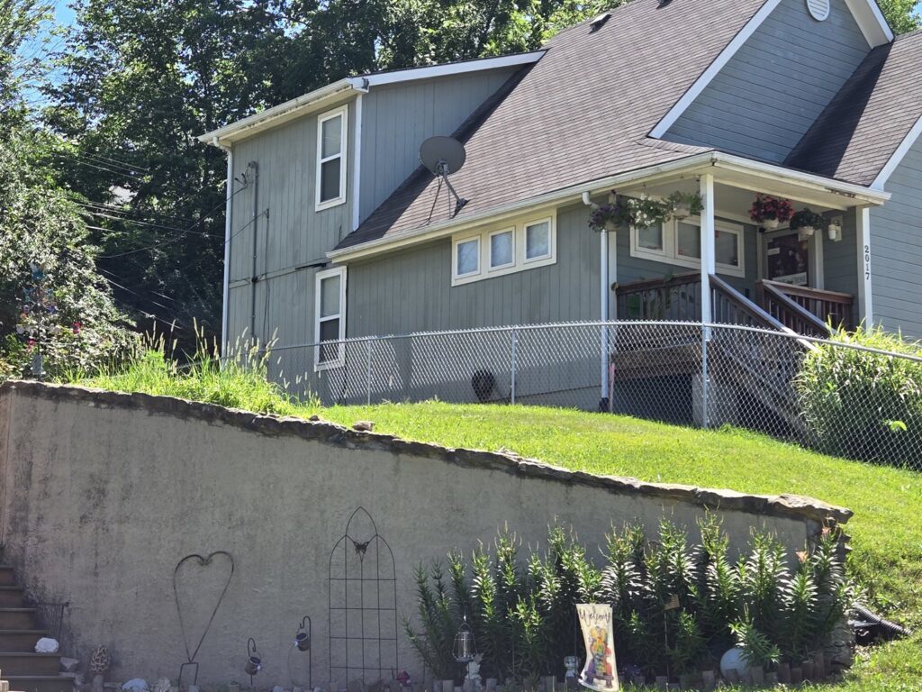 A chain-link fence installed on a sloped residential property by Sergio's Fence in Kansas City, KS.