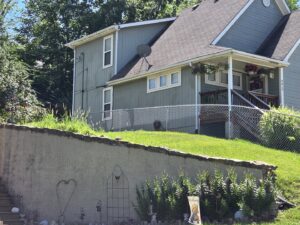 A chain-link fence installed on a sloped residential property by Sergio's Fence in Kansas City, KS.
