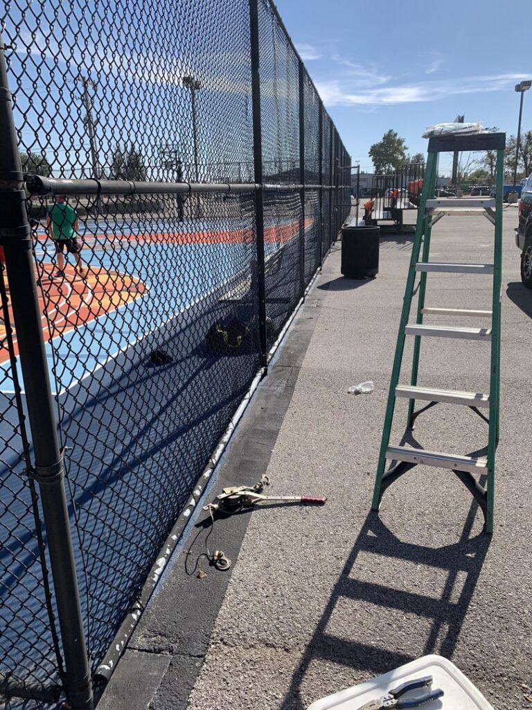 Chain link fence installation or repair around a colorful sports court by TOP TIER FENCE LLC in Oklahoma City, OK.