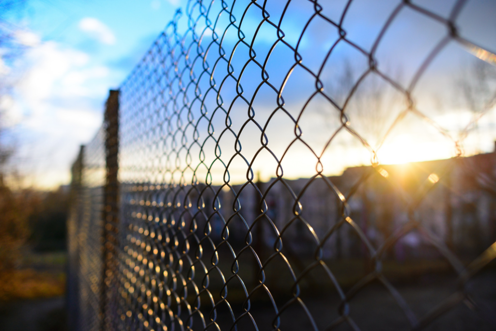 A chain link fence at sunset, a common installation by St. Charles Fence & Deck Company in Saint Peters, MO.