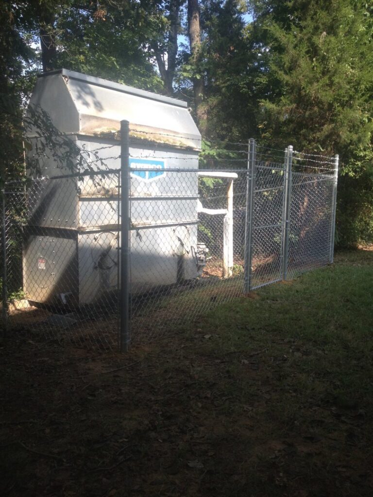 A chain-link fence enclosing a utility unit, installed by Timber Fencing in Charlotte, NC.
