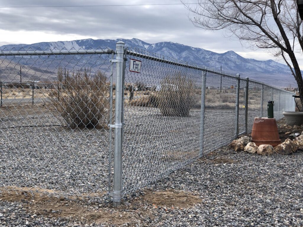 A durable chain-link fence with a secure gate installed in a rural setting by Finest Fence in Simi Valley, CA.
